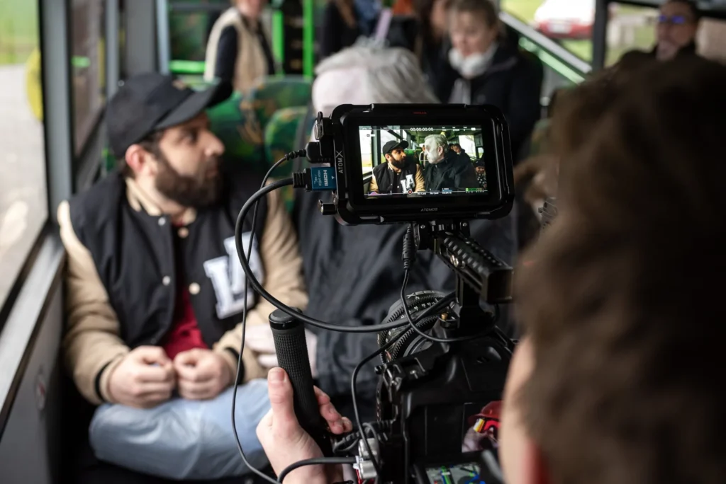 Natáčení v autobuse, na monitoru kamery je záběr herců